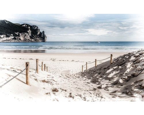 Sandiger Weg am Strand, der zum Ufer führt, mit dem blauen Meer im Hintergrund, Fototapete für einen ruhigen Strandspaziergang.