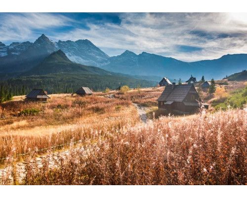 Fototapete mit majestätischen Bergen, die sich unter einem strahlenden Himmel erheben, mit weitreichenden Ausblicken auf die Natur.