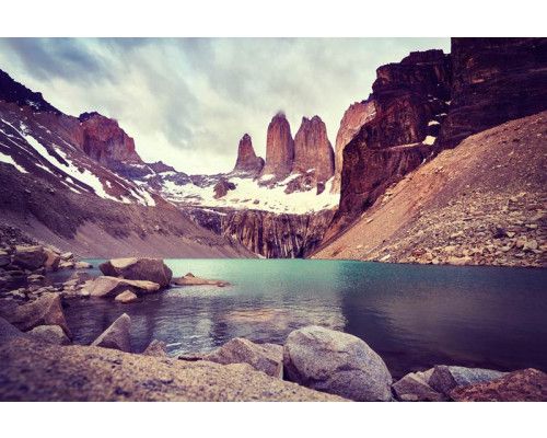 Fototapete des Torres del Paine Nationalparks in Chile, mit Bergen, die sich hoch über eine zerklüftete Naturlandschaft erheben.
