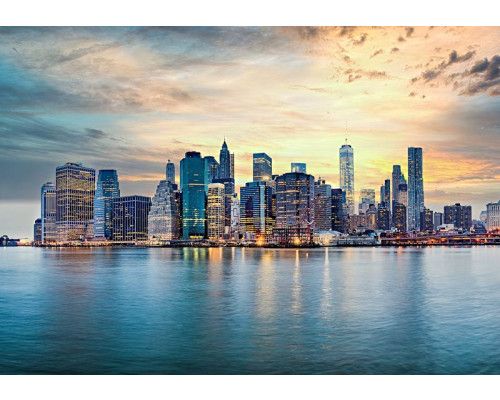 Fototapete New York Skyline bei Sonnenuntergang mit Wolkenkratzern und Spiegelung im Wasser.