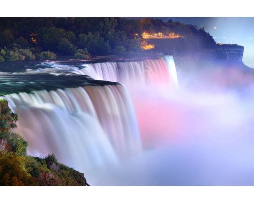 Fototapete von den Niagarafällen, wo das Wasser mit Wucht in die Tiefe stürzt und die umliegende Landschaft dominiert.