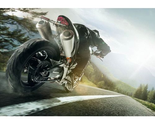 Fototapete schnelles Motorrad in den Bergen mit einer beeindruckenden Aussicht auf eine lange Straße und schöne Berge.