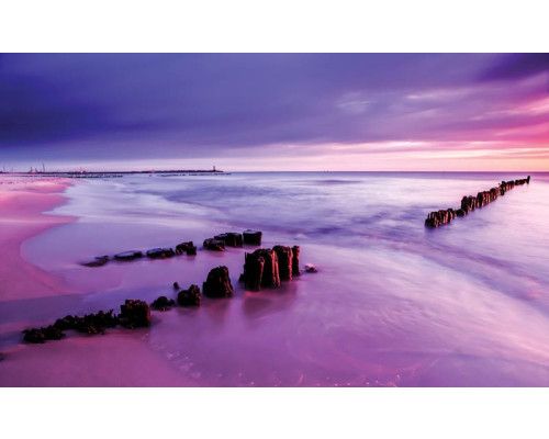 Fototapete, die einen farbigen Horizont bei einem Sonnenuntergang am Meer zeigt.