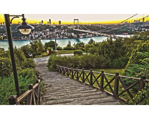 Fototapete mit Blick auf eine Stadt und eine Brücke in einer natürlichen Landschaft.