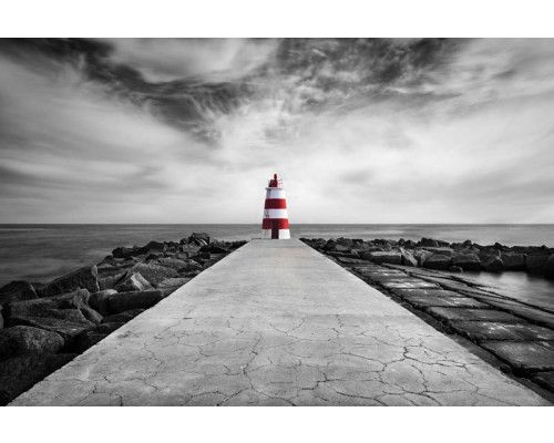 Fototapete eines Leuchtturms am Strand von Praia da Rocha, Algarve, mit dem Meer, das gegen die Küstenlinie plätschert.