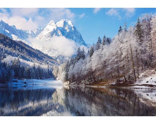 Fototapete einer Winterlandschaft mit schneebedeckten Bergen und einem ruhigen See, der das heitere Bild vervollständigt.