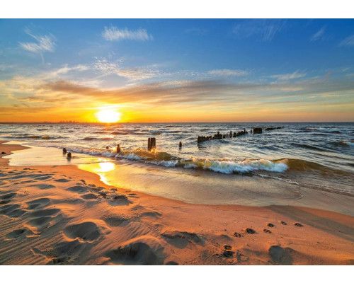 Fototapete mit einem Sonnenuntergang über dem Meer, mit einem hell erleuchteten Himmel und einer ruhigen Strandkulisse.