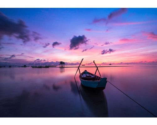 Fototapete von einem Sonnenuntergang über einem See und Meer, mit Landschaft, Boot und Kanu.