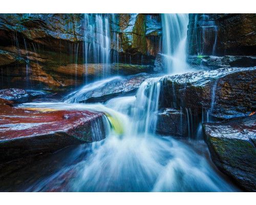 Fototapete eines Wasserfalls zwischen Felsen, natürliche Landschaft.