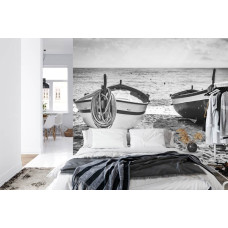 Eine Fototapete mit einer stimmungsvollen Strandszene mit Booten an einem ruhigen Meer, geeignet für ein Schlafzimmer.