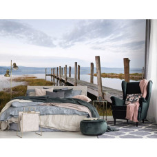Eine Fototapete mit einem Steg am See in einer Landschaft, zu sehen im Schlafzimmer.
