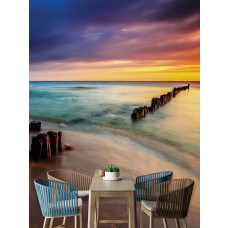 Eine Fototapete, die einen Strand bei Sonnenuntergang und einen farbenfrohen Horizont zeigt, platziert in einer Küchenumgebung.