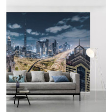 Eine Fototapete von einer beleuchteten Stadt mit Autobahnen durch die Landschaft im Wohnzimmer.