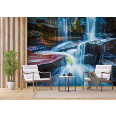 Wohnzimmer mit Fototapete Wasserfall zwischen Felsen, zwei Sesseln und einem kleinen Tisch.