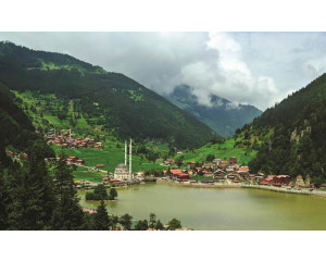 Fototapete mit einer malerischen Berglandschaft, mit Blick auf einen klaren See und Berggipfel.