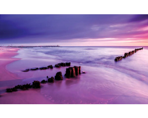 Fototapete, die einen farbigen Horizont bei einem Sonnenuntergang am Meer zeigt.