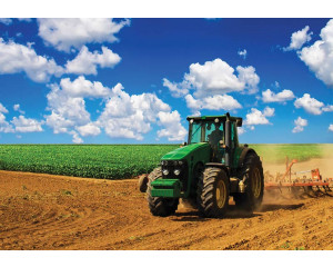Fototapete mit einem grünen Traktor in einer Landschaft, Thema Bauernhof.
