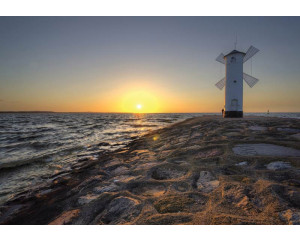 Meer und Windmühle bei Sonnenuntergang, gerendert auf einer Fototapete mit Leuchtturm und Felsen.