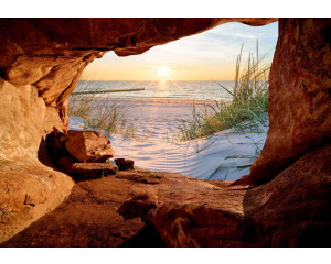 Fototapete eines Sonnenuntergangs über dem Meer, gesehen von einer Höhle mit Dünen und Strand.