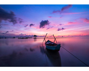 Fototapete von einem Sonnenuntergang über einem See und Meer, mit Landschaft, Boot und Kanu.